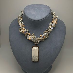 Fashion necklace in grey, whites and warm tone natural material beads.